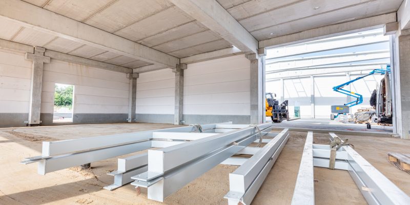 Warehouse construction site and steel profiles. Building a new industrial hall or storehouse